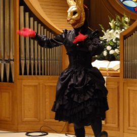 奇妙なうさぎのお面をつけてショーをする女性パントマイムアーティスト