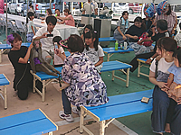 奈良県香芝市の自動車ディーラーお客様感謝祭の際に店舗前に設けられたステージ観客席で猿の写真撮影をするお客様 ショー終了後に猿の記念撮影をするお客様