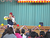 宮城県仙台市にある小学校の体育館を会場に開催された子ども会の秋のレクリエーションで子ども達の前でバルーンアートショーをする大道芸人 バルーンアートのショーをする大道芸人
