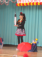 宮城県仙台市にある小学校のステージで秋のレクリエーションのアトラクションとして瓶など様々なものを使用したマジックを披露して観客の皆さんを驚かせる女性マジシャン 瓶などを使ったマジックをする女性マジシャン