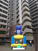 千葉県柏市のマンション前スペースに設置してキッズコーナーとして遊んでいただいたエアランドミニという青い恐竜が上についたエア遊具(ふわふわ) マンション前のスペースに設置して運営されたエアランドミニ