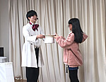 お手伝いとしてステージに上がってくれた女の子と一緒にパフォーマンスをする大道芸人 大道芸人