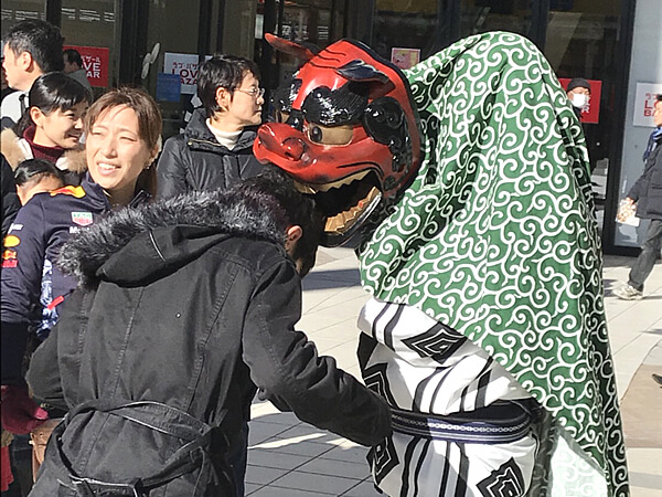 男性の頭を噛む獅子舞
