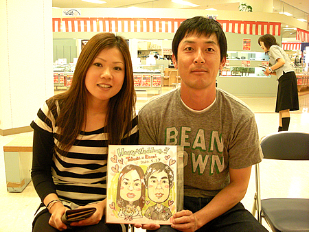 似顔絵をおかきしたカップル
